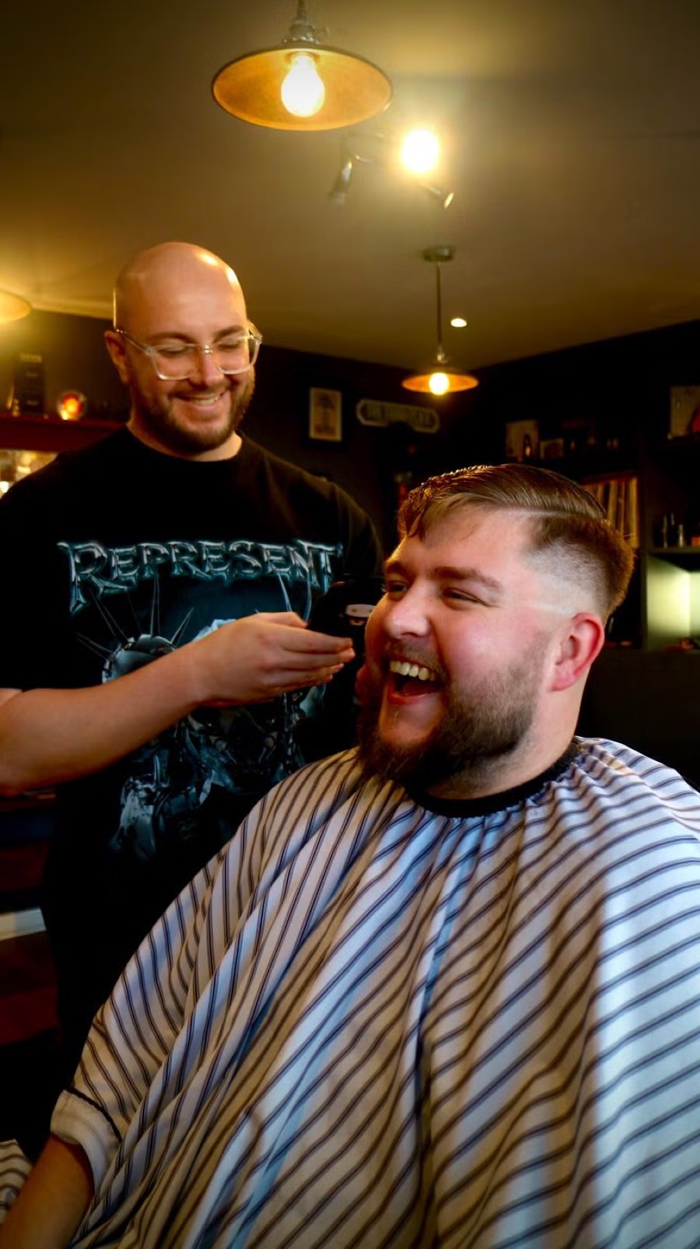 Barber and client sharing candid moment during trim